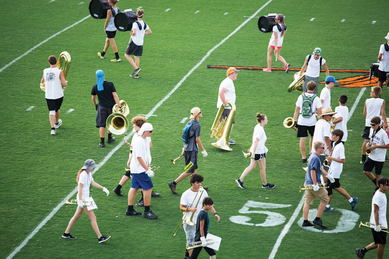 Despite the precision and polish that fans see at halftime shows, pre-game rehearsals, like this afternoon run-through at Powhatan High School, can appear more like chaos and confusion.